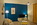 salon avec un mur bleu profond, un sol bois et du mobilier aux lignes scandinaves